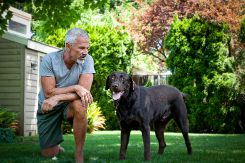 Michael G playing with his dog Rufus in the yard