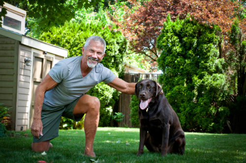 Michael G playing with his dog Rufus in the yard